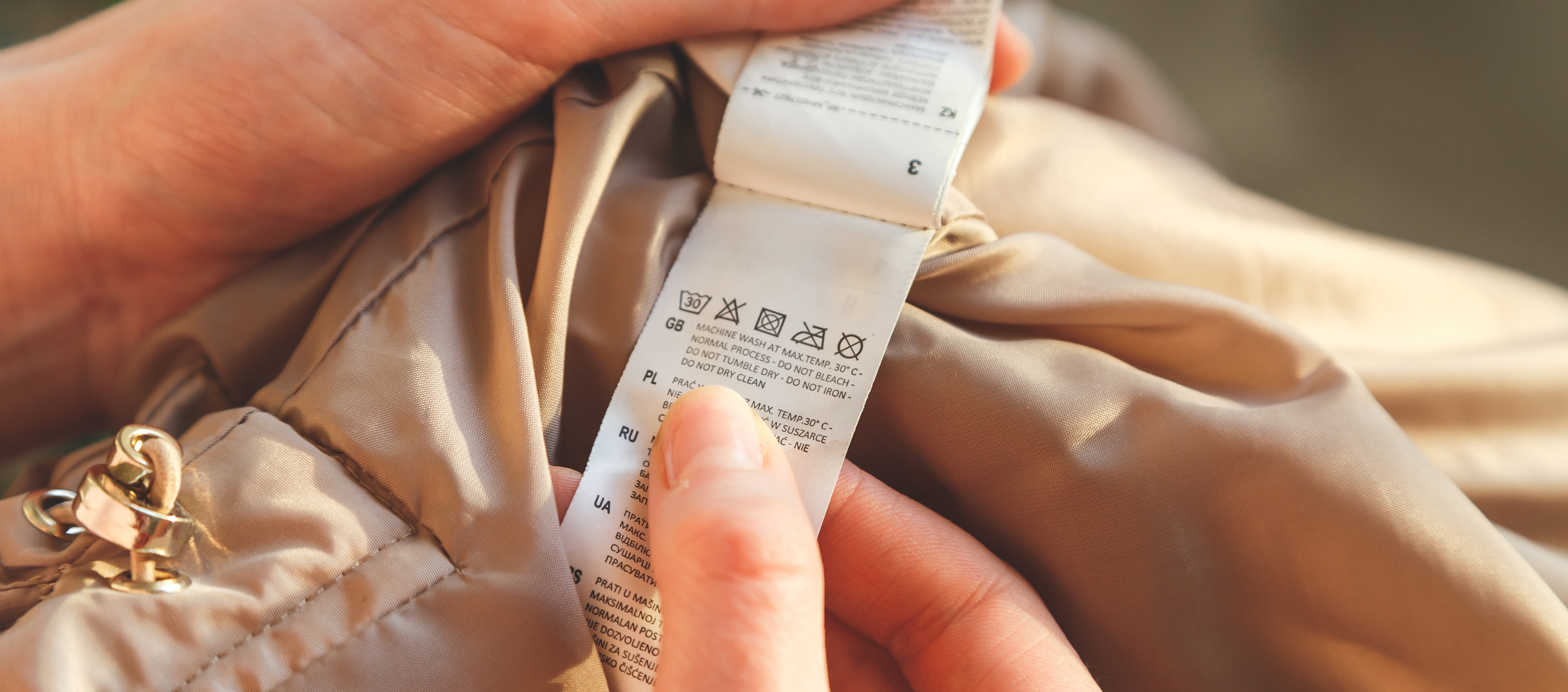 woman holds a tag of clothes with recommendations for care and washing