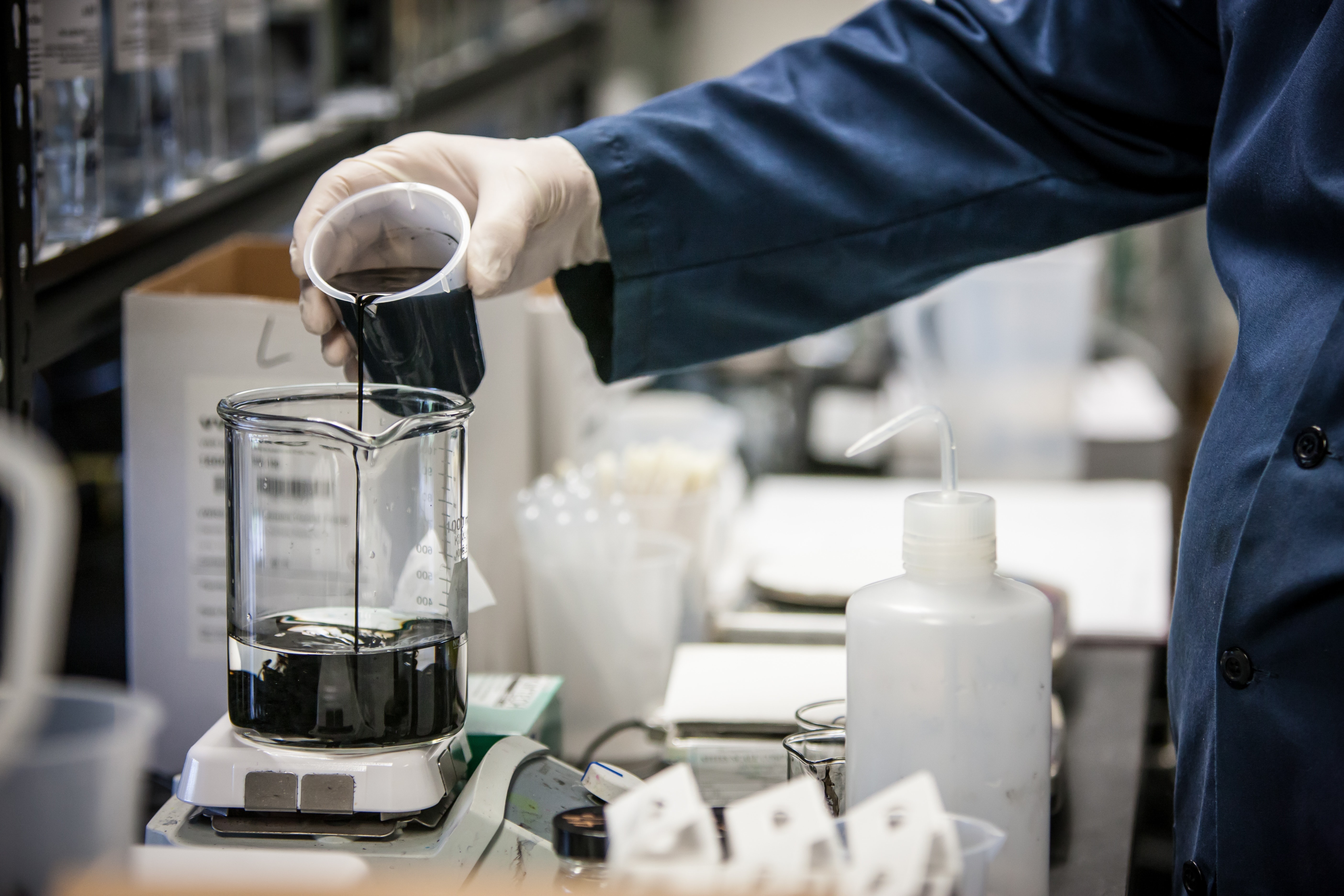 laboratory worker pouring beaker