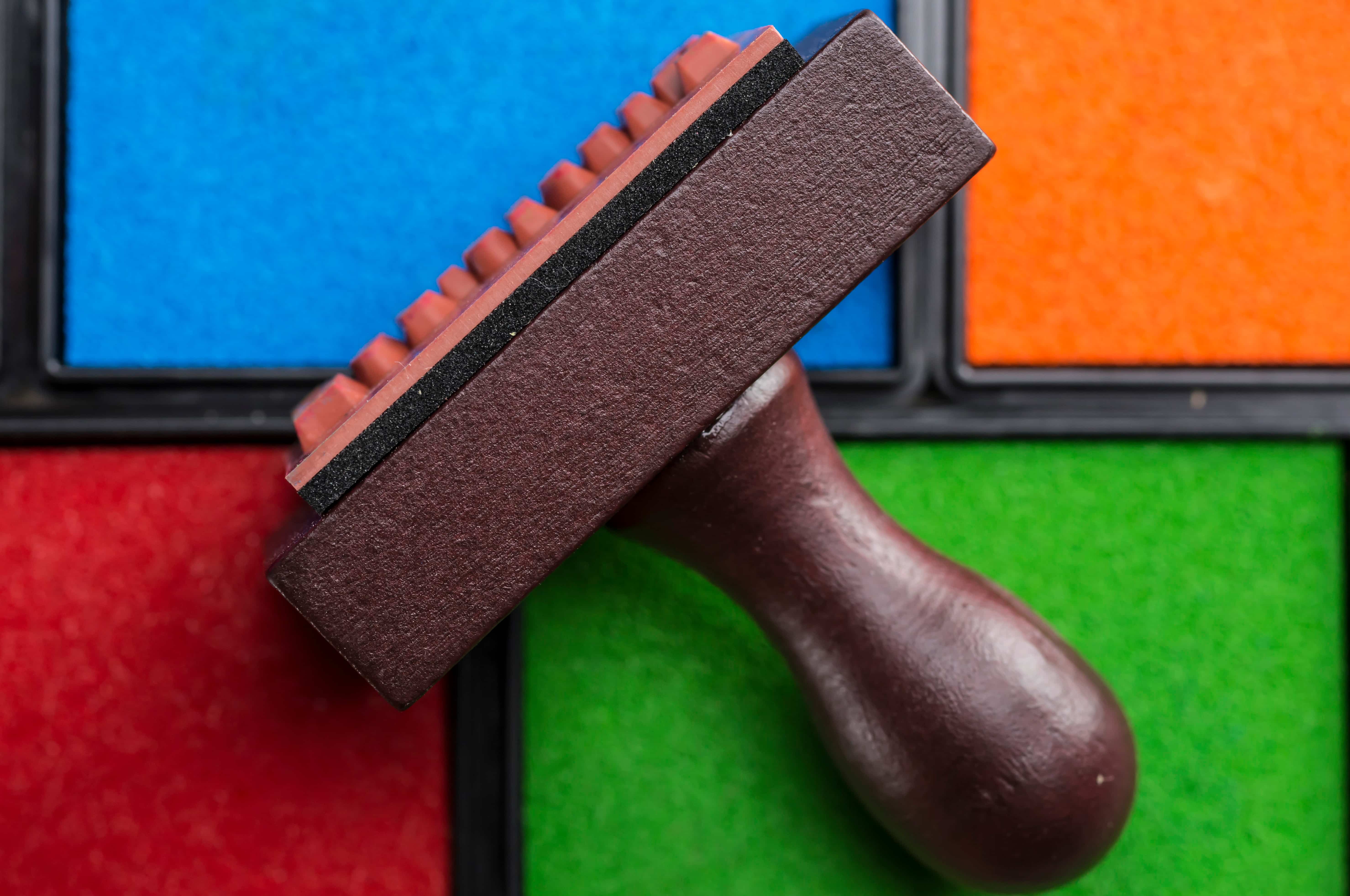 close up shot of rubber stamp and multiple colors of ink boxes